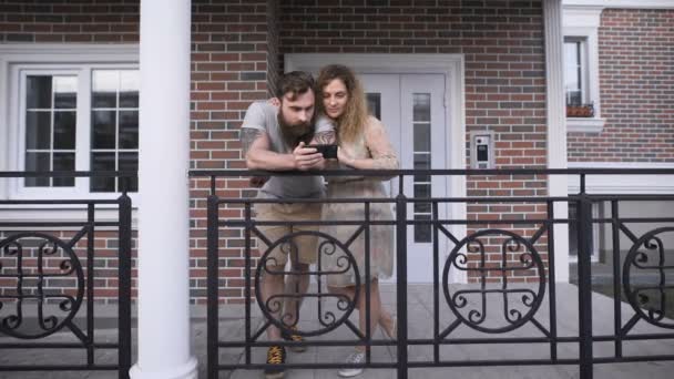 Married couple at doors of the house in the city. — Stock Video