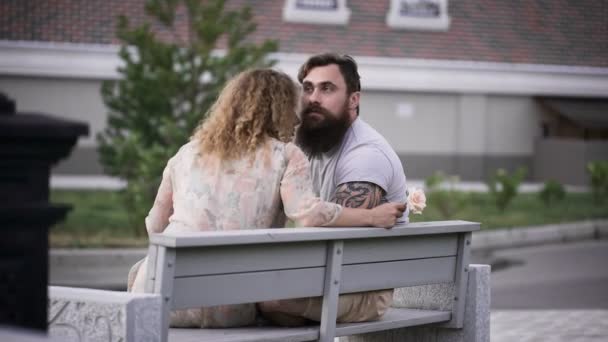 Couple aimant dans un temps ensoleillé assis sur un banc blanc . — Video