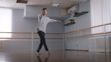 Genç adam güzel dans Contempo büyük, parlak bir stüdyoda dans. Deneyimli dansçı bir u dönüşü yapar ve sonra yere düşer.
