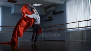Profesyonel dansçı onun dance önünde kırmızı kumaş güzel dalgasının tamamlanır. Adam büyük bir kırmızı bez alır ve sonra yere koyar. Modern dans.