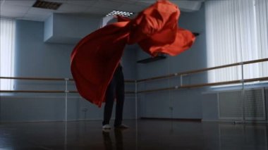 Dansçı onun duygusal dance büyük bir stüdyoda büyük bir kırmızı bez kullanarak gerçekleştirir. Modern dans için öznitelikleri. Zarif dans yetenekli adam tarafından gerçekleştirilen.