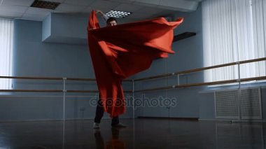 Prova salonda genç adam. Tablo için dans provası. O kırmızı kumaş aracılığıyla rotasyonu yapıyor. Grace dansa kumaş verir.