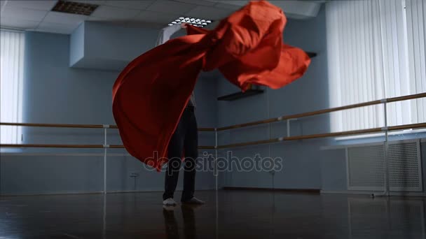 Dançarino executa sua dança emocional usando um grande pano vermelho em um grande estúdio. Atributos para a dança moderna. dança graciosa realizada por cara talentoso . — Vídeo de Stock