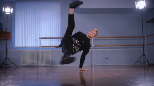 검은 바지와 스웨터 urbanstyle와 스트리트의 요소로 handstand을 수행에 젊은 힙합 댄서의 클로즈업. — 비디오