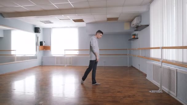 Танцовщица в зале для репетиций. Он работает над движениями для танцев. Современный - современный сценический танец, включающий самые разнообразные направления и техников . — стоковое видео