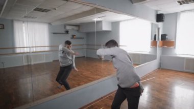 Dansçı ayna dans ediyor. Bir pencere ile hafif dans dersi. Dans aynada yansıması. Bir dansçı dans hareketleri ayna yakınındaki prova.