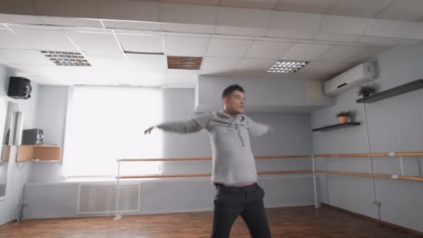 Man is dansen in dansstudio. Dans bewegingen repetitie. Air conditioning in de dansstudio. Beweging van handen. — Stockvideo