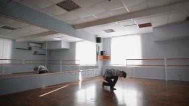 Akrobatik dans dans stüdyosu. Dansçı, dans için hüner gerçekleştirir. Dizlerinin dans düşüyor. Hafif dans Oda hemen windows ve klima ile.