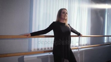 Güzel ev hanımı bir dans stüdyoda bale barre dans önce bir egzersiz yapar. Yetişkin bir kadının yapması ağız kavgası ve bacak çeker.