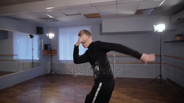 Närbild av unga Rap dansare i svarta byxor och tröja utför urban Dans i klassrummet. Pojke flyttar sina armar och ben visar freestyle och modern dans. — Stockvideo