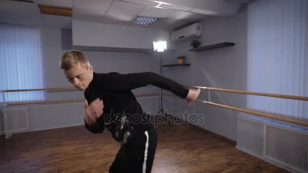 Jonge kerel doet actieve dans beweegt en schopt in de dansstudio. Danser gericht op het uitvoeren van hiphop dans moves. — Stockvideo