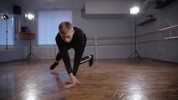Danser in zwarte shirt en broek moderne breakdancing in klas met spiegels en ballet barre tonen. Jongeman is het aantonen van prachtige elementen van streetdance. — Stockvideo