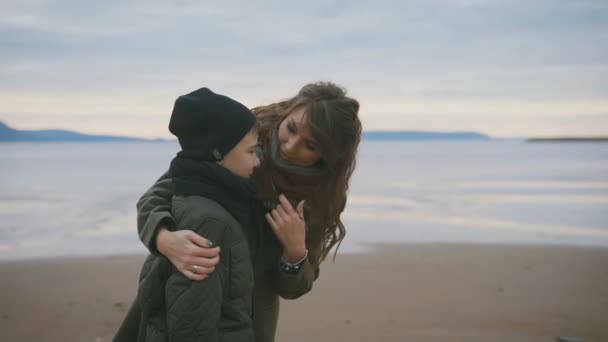 Matka i syn na nabrzeżu. Kobieta, przytulanie dziecka. Dziecko jest w doskonały nastrój towarzyszy jego matka. Razem spędzają swój wolny czas. — Wideo stockowe