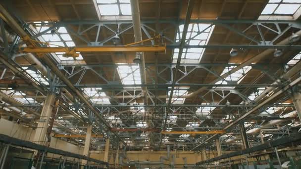 De premisse van de productie met een hoog plafond en een groot aantal industriële apparatuur over het gehele grondgebied. Veel metalen constructiewerken, ventilatie buizen gebruikt in de bouw. Grote lichte ramen in — Stockvideo