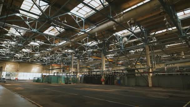 Local de producción con un techo alto y un gran número de equipos industriales en todo el territorio. Muchas estructuras metálicas, tubos de ventilación utilizados en la construcción de edificios. Grandes ventanas de luz en — Vídeo de stock