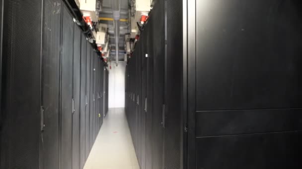 Une longue série d'armoires spéciales conçues pour le serveur de ventilation sur une grande installation industrielle. Dispositifs connectés à une alimentation commune par des câbles avec fiche rouge. Couloir mince avec lampe pour l'éclairage .