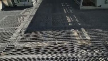 Kamera havalandırma donatımın satırlar arasında hareket eder. Çalışanlar, geçiş yapılan dayanıklı mesh için endüstriyel bir binanın çatısında bir yolu vardır.