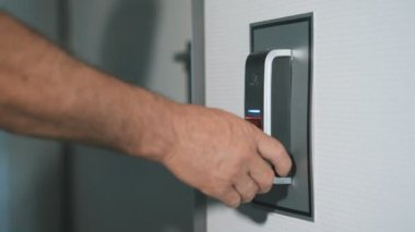 Adam kapıyı girmek için tasarlanmış bir parmak izi tarayıcı parmağını koyar. Modern güvenlik teknoloji çalışanların günlük hayatımızda. Hırsızlık karşı koruma çalışmalarını yakın çekim.