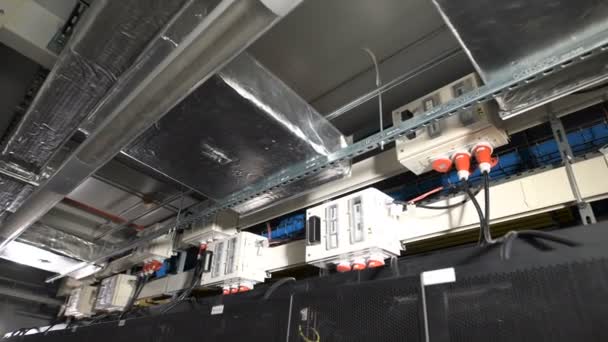 Varias unidades de energía eléctrica están equipadas con un interruptor interior, unido bajo el techo en las instalaciones industriales de las empresas de TI. Dispositivos conectados a un suministro común mediante cables con enchufe rojo . — Vídeo de stock