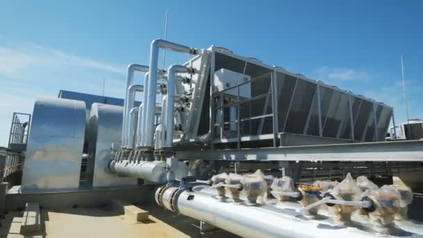 Metal chrome pipes are connected to a common water supply system for the enterprise. On the roof of an industrial building organized piping and ventilation. — Stock Footage Metal chrome pipes are connected to a common water supply system for the enterprise. On the roof of an industrial building organized piping and ventilation. Stock Video