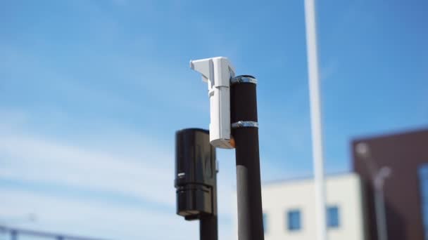 Systeem van videobewaking en bewegingssensoren bevinden zich op de hoek van de close-up van het hek. Moderne apparatuur voor de bescherming van het grondgebied van buitenstaanders. Gebouwen op de achtergrond. — Stockvideo
