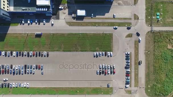 Inquérito aéreo de estacionamento perto da fábrica, em torno do qual os gramados verdes. Passeios de carro em um estacionamento em busca de um espaço de estacionamento . — Vídeo de Stock