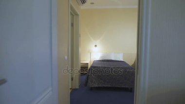İki özenle yapılmış yataklar ve duvar lambaları ile rahat otel odasında. Kamera odadan odaya taşır. Yumuşak yastıkları yatakta yatıyordu.