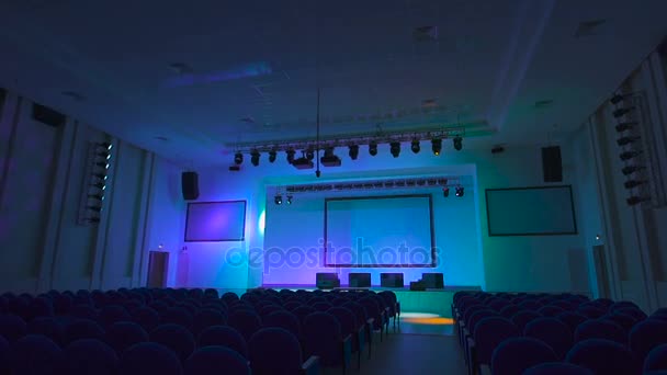 Work of lighting equipment is checked before the start of a large concert in modern hall. Multi-colored lights shine on the concert hall. — Stock Video