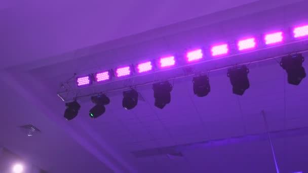 在工作中的音乐会照明设备。专业照明自动旋转投影仪和不同颜色的闪光。进入镜头的光线从光设备. — 图库视频影像