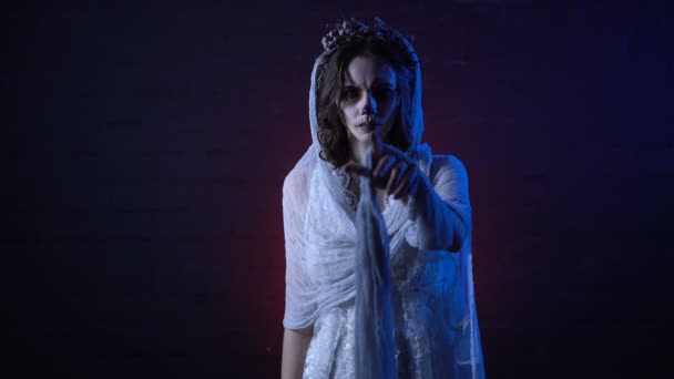 Φάντασμα του μοναχικό νεκρή νύφη σε λευκό νυφικό φόρεμα και πέπλο στέκεται με θλιμμένο πρόσωπο που κινείται το χέρι της. Τρομακτικό κορίτσι μακιγιάζ apperance Απόκριες τρόμου φόντο. Μυστηριώδης γυναίκα είναι μόνη — Αρχείο Βίντεο