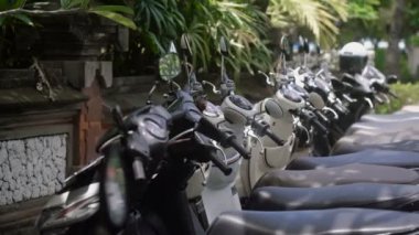 Birkaç scooter üst üste sokakta park edilmiş. Şehir etrafında seyahat için uygun ulaşım.