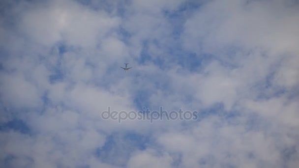 Plane is flying at a high altitude in the sky. Aircraft flies into the distance among a large number of nearly transparent clouds. — Stock Video