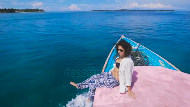 A rapariga da ilha de Bali excursões. Ela se senta na beira do barco, admirando o oceano azul-turquesa e limpo. Apenas seu deslumbramento belas vistas ao redor . — Vídeo de Stock