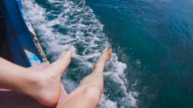 Teknedeki adam Hint Okyanusunda geziler. Turkuaz Okyanusu hayran teknenin kenarında oturur ve temiz. Bali-harika plajları ile bu adayı temizleyin zümrüt suların