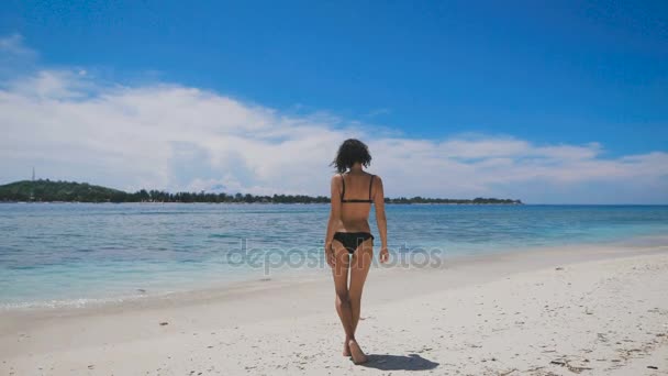 Szexi brunnete fekete bikini a forró nyári napon a sun beach, Bali szigetén fürdeni. Alkalmas fiatal lány élvezi a trópusi nyaralás a tengerparton, Indonézia, szolárium és a légzés.