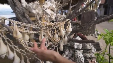 Bali seyahat eder. Yürürken kabukları üzerinde asılı bir ağaç gördü. O bir el onları tutan ve sesler sahiptir.