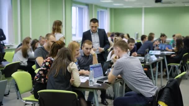 Středu diskusí ze semináře. Tým studentů spolu s hlavou zobrazit prezentaci v přenosném počítači. — Stock video