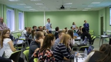 Ünlü hoparlör seyirciler atölye işlemindeki izlerken merkezi olarak mikrofon ile. Öğrenciler seyirciler dikkatle projektörden resme benziyor.