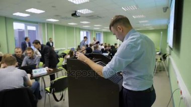 Yakışıklı öğretmen sınıfta öğrencilerin önünde sunuyu başlatmak hazırlanıyor Beyaz gömlekli.