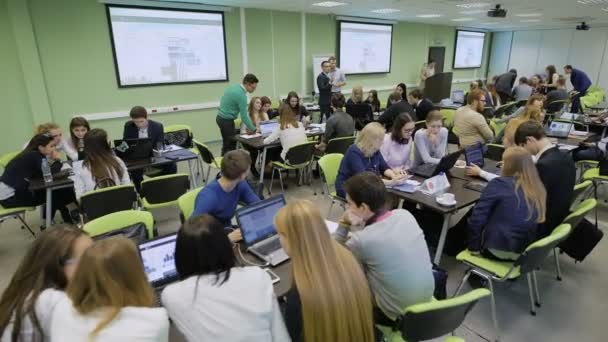 Εκπαιδευτικό διαγωνισμό στην αίθουσα διδασκαλίας στο Πανεπιστήμιο με diffferent ομάδες μαθητών. Το ακροατήριο συνεδρίαση στα γραφεία και την εργασία με φορητούς υπολογιστές που κάνουν ασκήσεις και πρακτική — Αρχείο Βίντεο