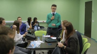 Sınıflar Üniversitesi'nde sonu. Yeşil ceketli grup başkanı eğitim sonuçlarını diyor. Öğrenciler dinlemek ve onların laptops-toplamak.