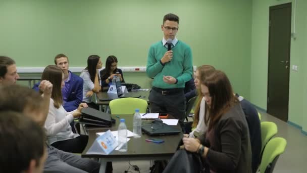 Sınıflar Üniversitesi'nde sonu. Yeşil ceketli grup başkanı eğitim sonuçlarını diyor. Öğrenciler dinlemek ve onların laptops-toplamak. — Stok video