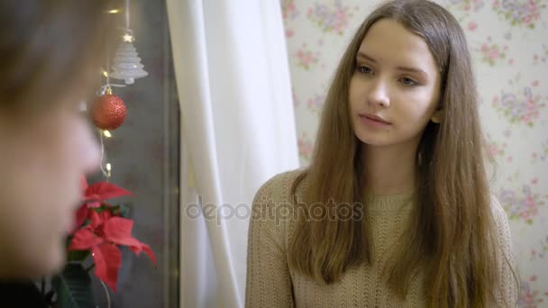 Portret van jonge aantrekkelijke brunette. Mooi meisje zitten in een cafe met mijn vriendje en flirterige praat met hem. Patisserie, waar koffie en cupcakes. Rond Kerstmis decoratie — Stockvideo