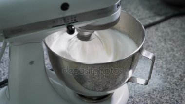 Mikser ekmek mutfakta metal kapta yumurta akı ile işaretlenmiş krem. Profesyonel ekipman tatlılar hazırlanması için. Corolla hızla döner.