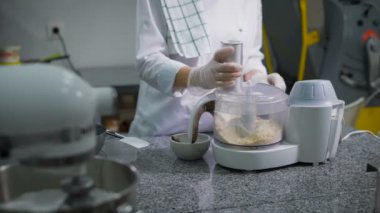 Pudra profesyonel mutfak robotu içinde çeşitli tatlılar yapmak için malzemeler biler. Ön planda bir karıştırıcı bir pasta için krema ne arar.