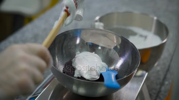 Kök. Process av förberedelse av de franska mandelolja cookies. Kvinnan lägger vit vikt till en skål med lila sirap. — Stockvideo