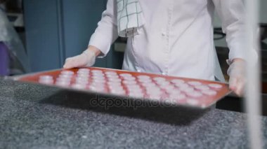 Bir şekerci dükkânı bir tatlı hazırlama süreci. Kadın pasta beyaz fırın içinde birkaç kez kaldırdı ve onları tablo yüzeyinde de darbelere.