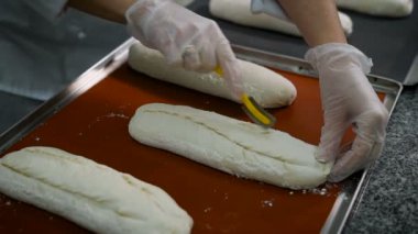Elleri parlak desenli eldiven giymiş kadın Pastacı, insizyon yakında lezzetli bir ekmek olacak ıslak test yapar.