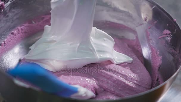 Cocina en la tienda de dulces. Proceso de preparación de los macarrones franceses. El peso blanco se añade a un tazón con jarabe rosa . — Vídeos de Stock