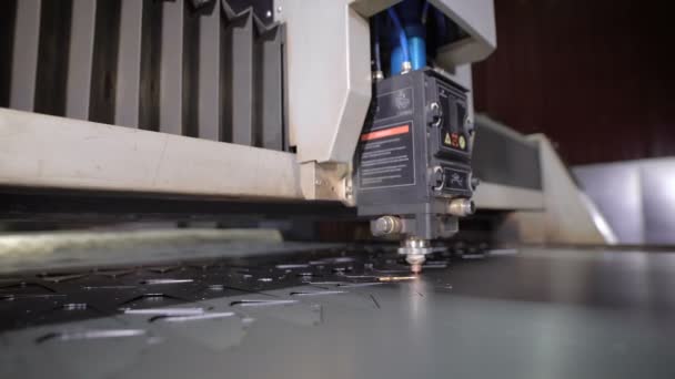Industriële laser cutter met vonken. De geprogrammeerde robot hoofd snijdt met behulp van een groot vel metalen temperatuur. Moderne machine verbetert de kwaliteit en productiviteit. — Stockvideo